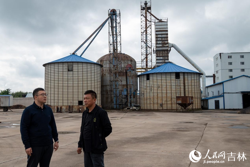 农行工作人员向丰谷粮食加工了解经营状况。